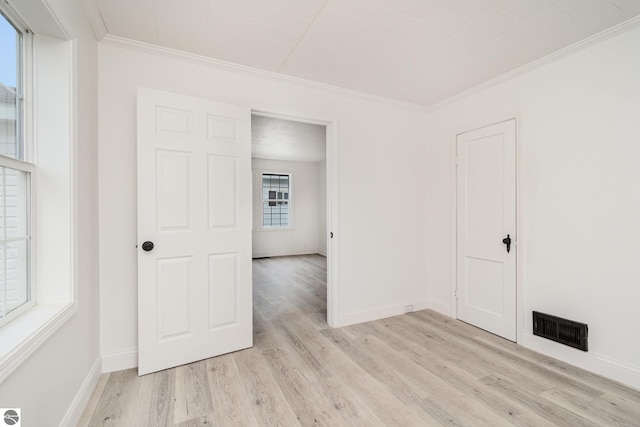 726 Pennsylvania Ave, Alma, MI 48801 - empty room featuring light wood-type flooring, plenty of natural light, and ornamental molding