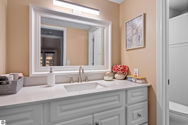 bathroom with vanity, toilet, and a textured ceiling