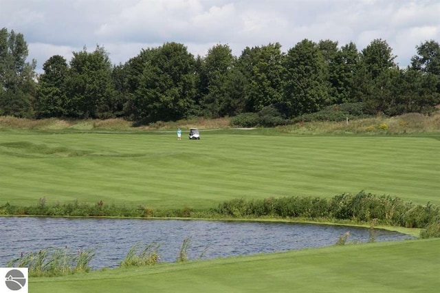 surrounding community featuring a lawn and a water view