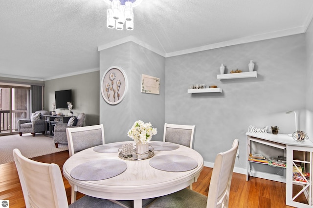 dining area featuring ornamental molding, a textured ceiling, and hardwood / wood-style flooring