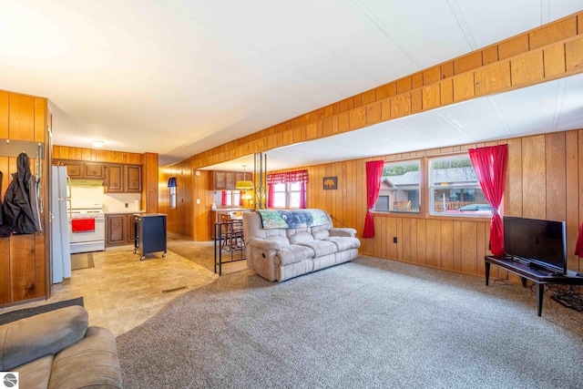 living room with light carpet and wood walls