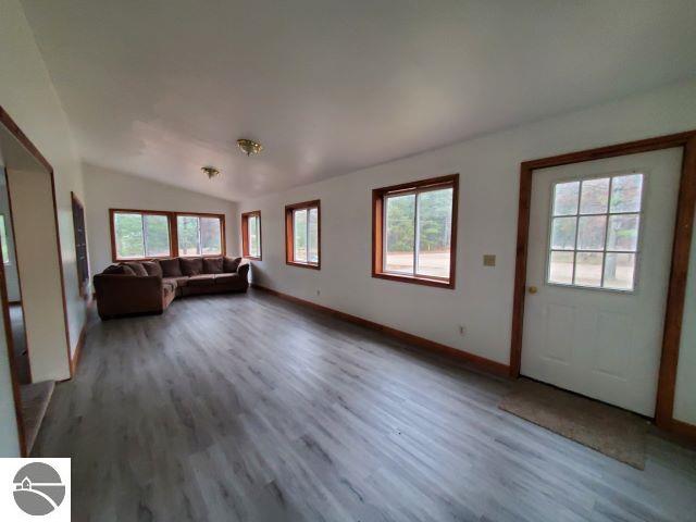 unfurnished living room featuring lofted ceiling and hardwood / wood-style flooring