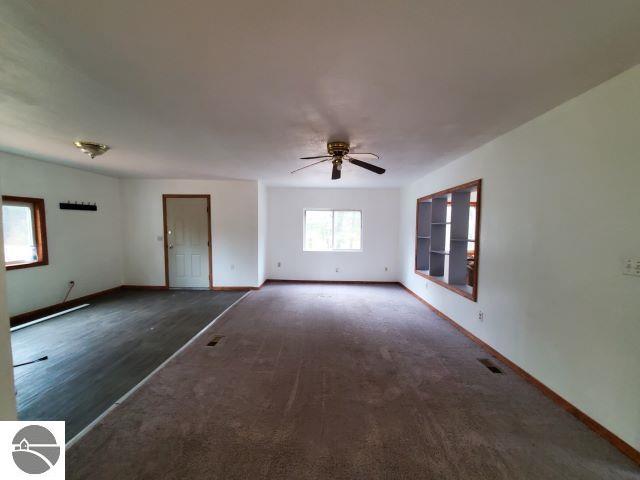 empty room with dark hardwood / wood-style flooring and ceiling fan