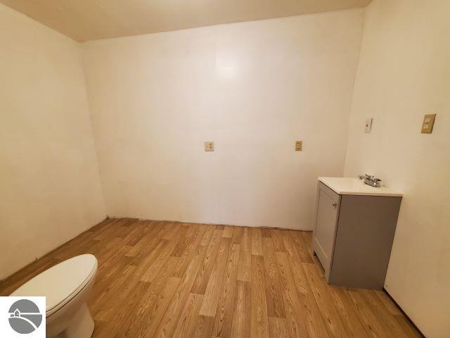 bathroom featuring wood-type flooring, toilet, and sink