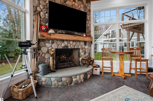 91 S Nanagosa Trl, Suttons Bay, MI 49682 - living room featuring a stone fireplace, plenty of natural light, and carpet floors