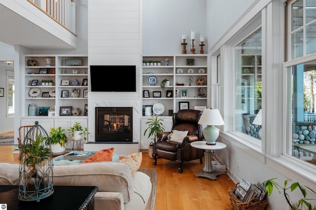 91 S Nanagosa Trl, Suttons Bay, MI 49682 - living area with a multi sided fireplace, wood finished floors, and built in shelves