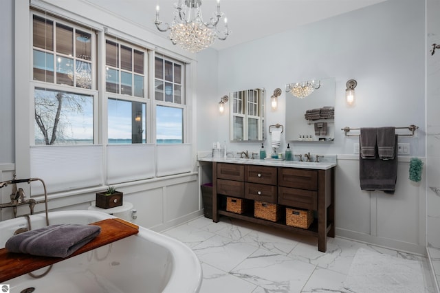 bathroom with a bathing tub, vanity, and a chandelier