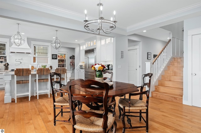 dining space featuring light hardwood / wood-style flooring, crown molding, and a notable chandelier