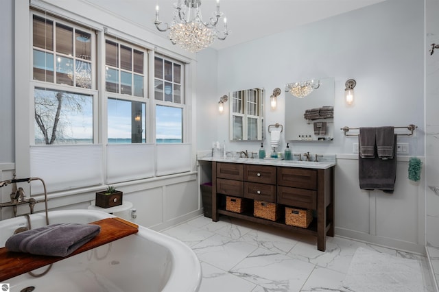 91 S Nanagosa Trl, Suttons Bay, MI 49682 - full bathroom with marble finish floors, a chandelier, a freestanding tub, double vanity, and a decorative wall