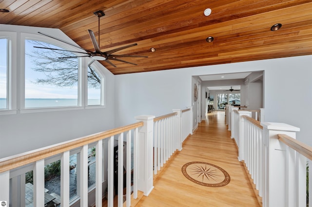 corridor with a healthy amount of sunlight, wooden ceiling, light hardwood / wood-style flooring, and lofted ceiling