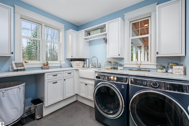 laundry area featuring cabinets, washer and clothes dryer, and sink