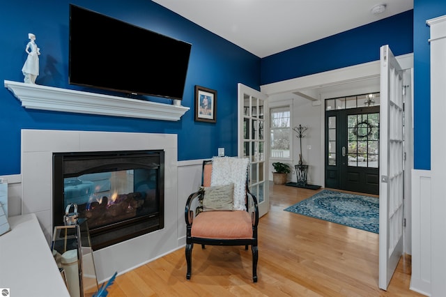 entryway featuring a multi sided fireplace and light hardwood / wood-style flooring