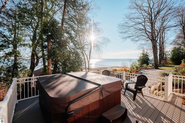 wooden terrace featuring a water view and a hot tub