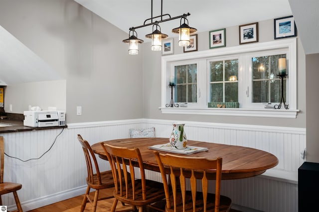 dining space featuring breakfast area, vaulted ceiling, and hardwood / wood-style flooring