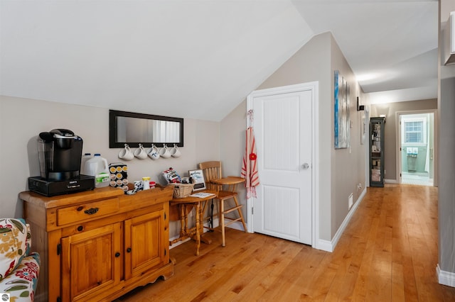 interior space with light hardwood / wood-style floors and vaulted ceiling