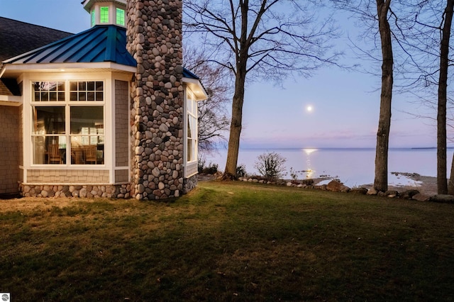 91 S Nanagosa Trl, Suttons Bay, MI 49682 - yard at dusk with a water view and a lawn