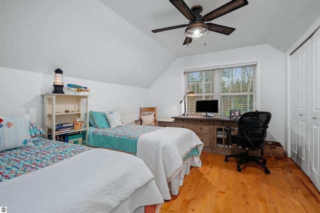 bedroom featuring ceiling fan, lofted ceiling, light wood-type flooring, and a closet