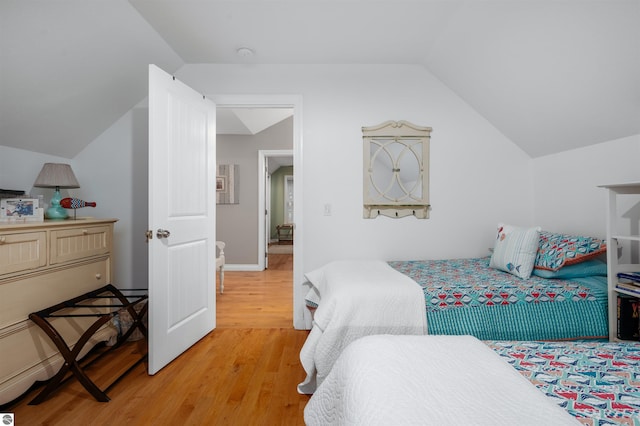 bedroom featuring hardwood / wood-style floors and vaulted ceiling