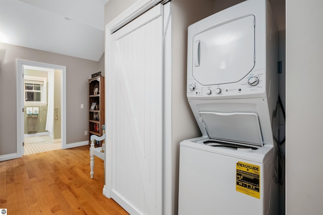 91 S Nanagosa Trl, Suttons Bay, MI 49682 - washroom with stacked washer / drying machine, light wood-type flooring, and baseboards