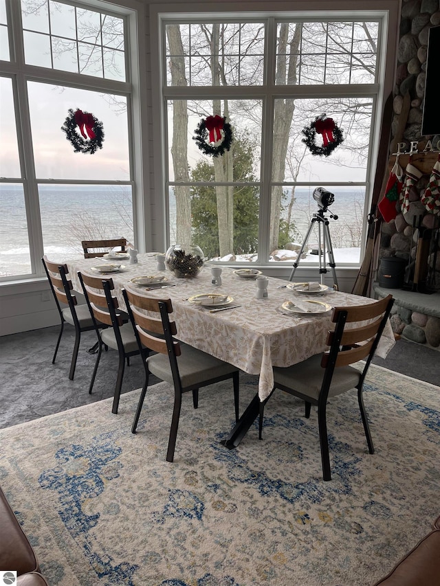 dining space featuring plenty of natural light and a water view