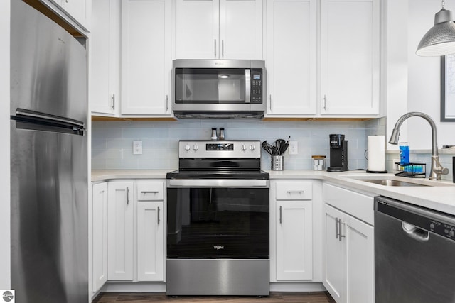 kitchen with appliances with stainless steel finishes, white cabinetry, and sink