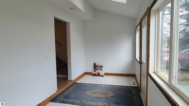 spare room featuring light hardwood / wood-style floors, vaulted ceiling, and plenty of natural light