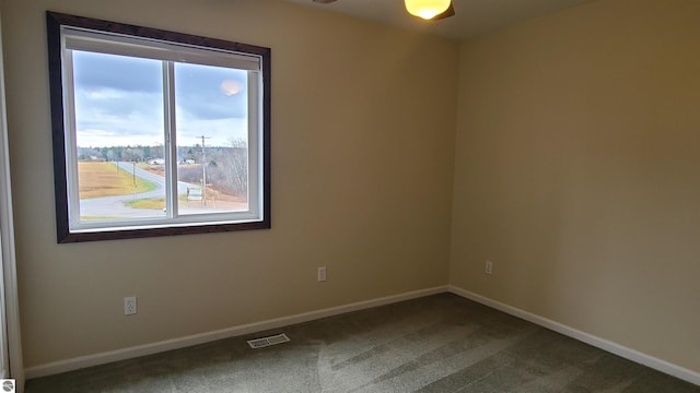 carpeted spare room with ceiling fan