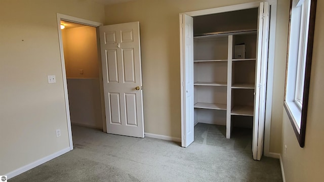 unfurnished bedroom with light carpet and a closet