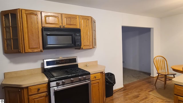 kitchen with stainless steel gas stove and wood-type flooring