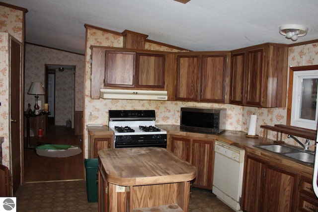 kitchen featuring vaulted ceiling, sink, a textured ceiling, and white appliances