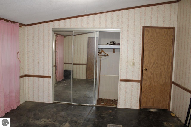 unfurnished bedroom with a textured ceiling, crown molding, a closet, and vaulted ceiling