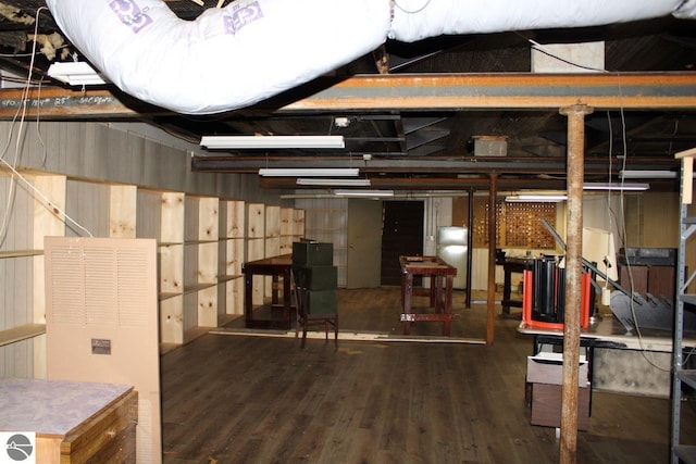 basement featuring wood walls and dark hardwood / wood-style flooring