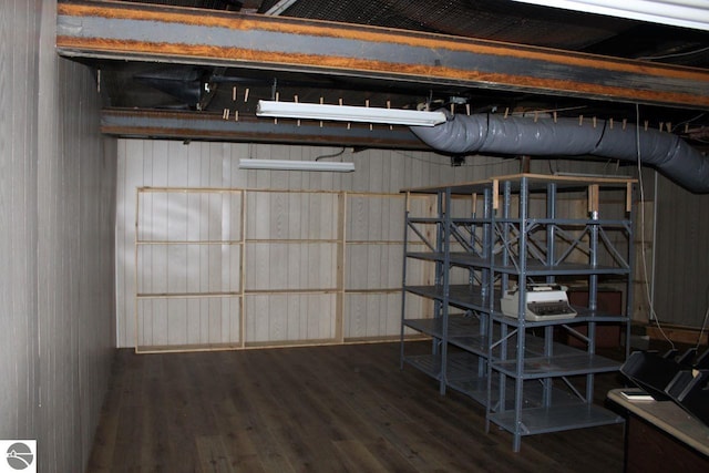 basement featuring wood-type flooring and wood walls