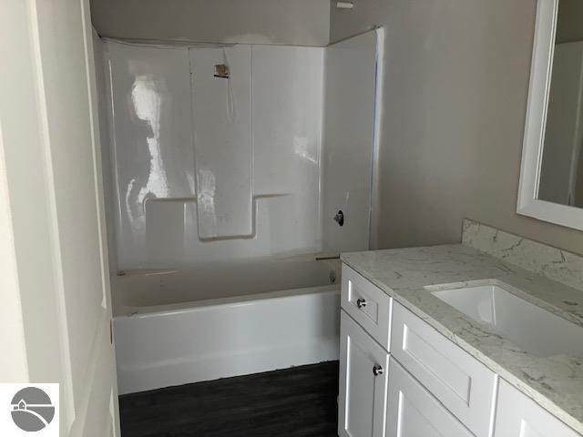 bathroom featuring hardwood / wood-style floors, vanity, and bathtub / shower combination