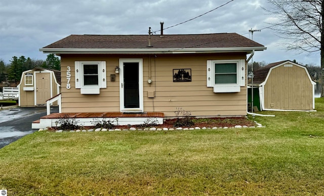 bungalow-style house with a front yard and a shed