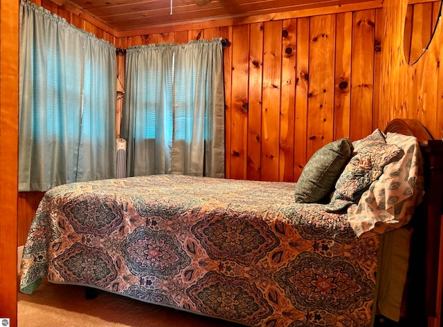 bedroom with wood ceiling, carpet floors, and wooden walls