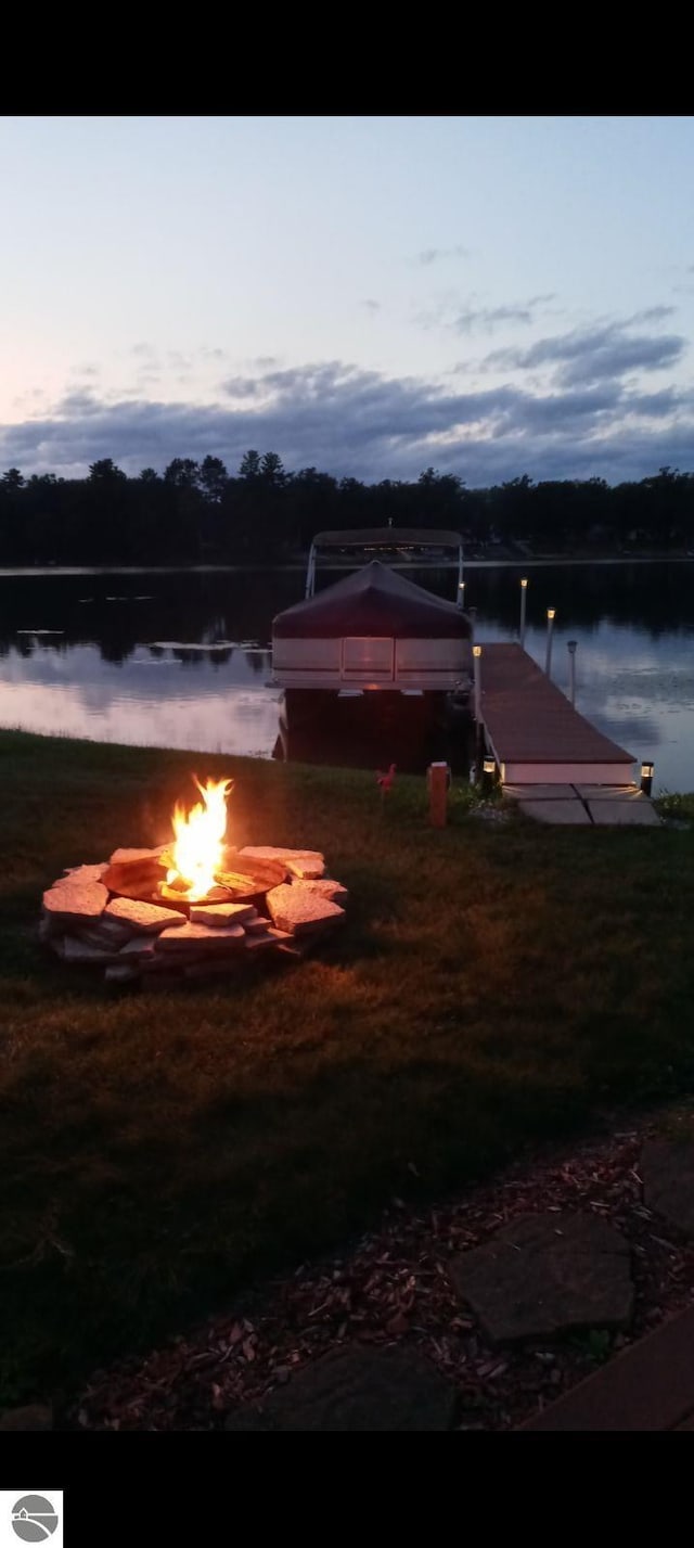 water view featuring a boat dock and a fire pit