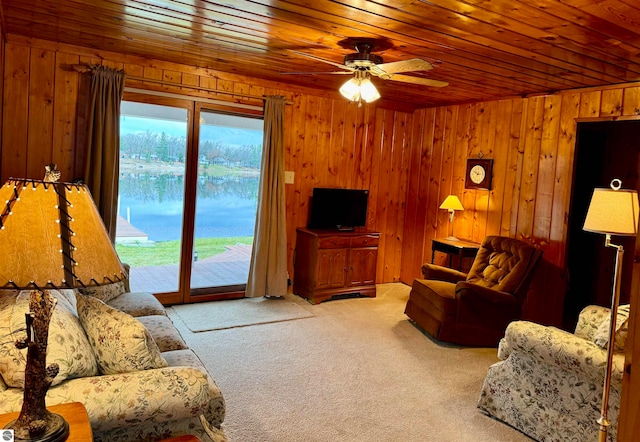 carpeted living room featuring ceiling fan, wood walls, and wood ceiling