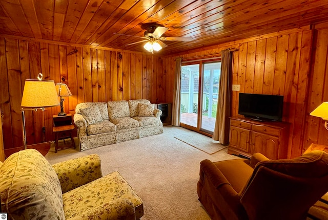 carpeted living room featuring wooden walls, ceiling fan, and wooden ceiling