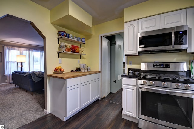 kitchen featuring dark wood-type flooring, stainless steel appliances, white cabinets, and butcher block counters