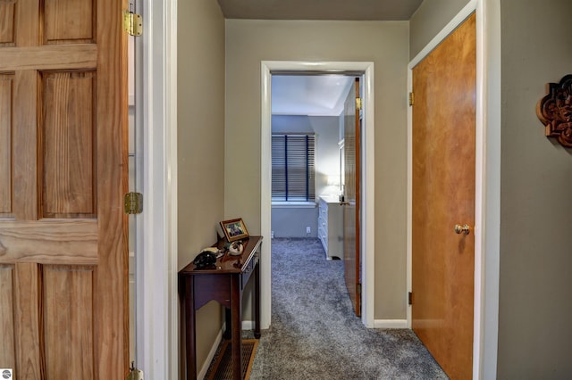 hall featuring dark colored carpet