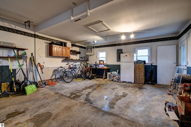 garage featuring white fridge and electric panel