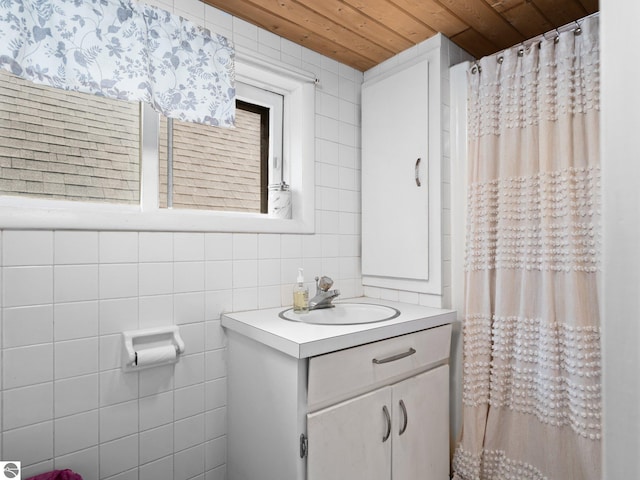 bathroom featuring vanity, wood ceiling, and tile walls