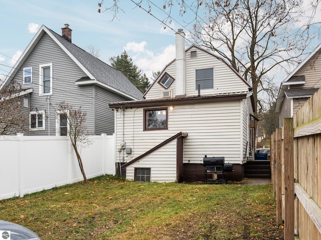 rear view of property featuring a lawn