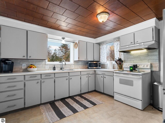 kitchen with backsplash, gray cabinetry, sink, and white electric stove