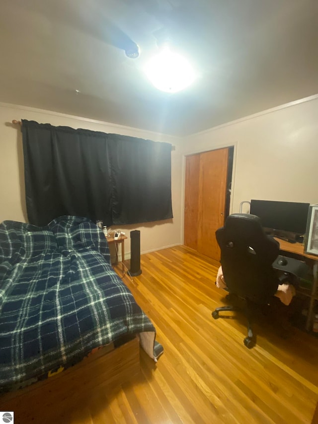 bedroom with hardwood / wood-style flooring and ornamental molding