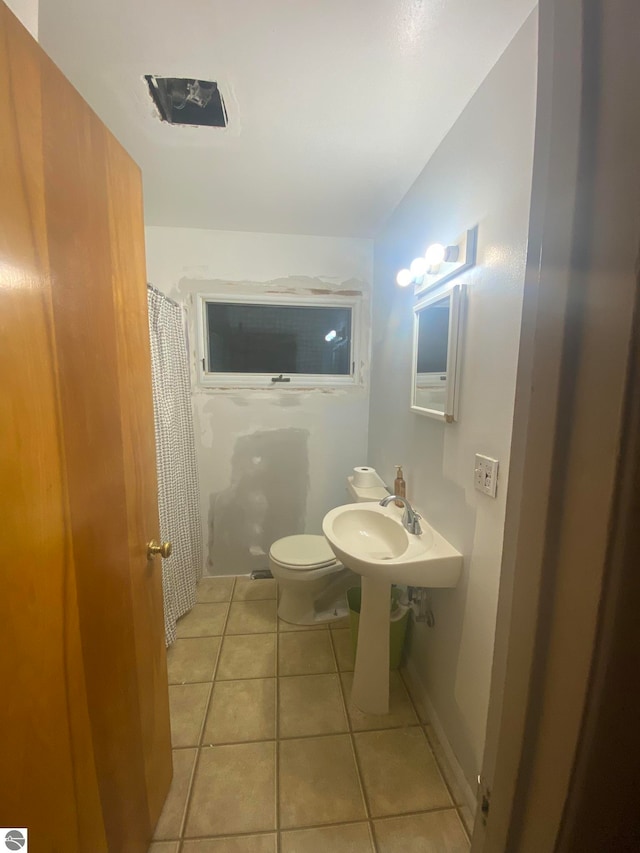 bathroom with tile patterned flooring, toilet, and a shower with shower curtain