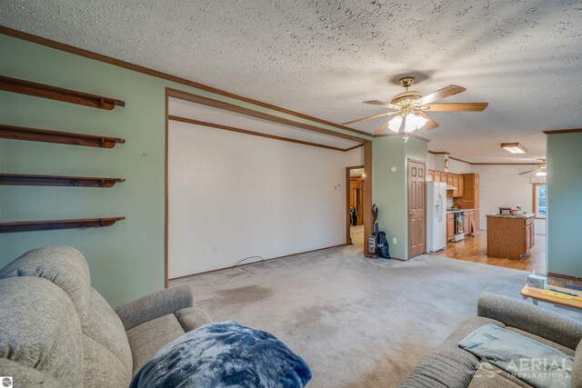 carpeted living room featuring a textured ceiling, ceiling fan, and ornamental molding