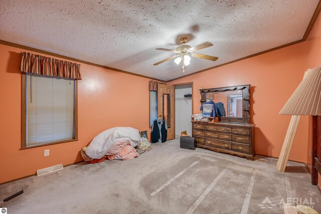 bedroom with lofted ceiling, carpet flooring, ceiling fan, a spacious closet, and a textured ceiling