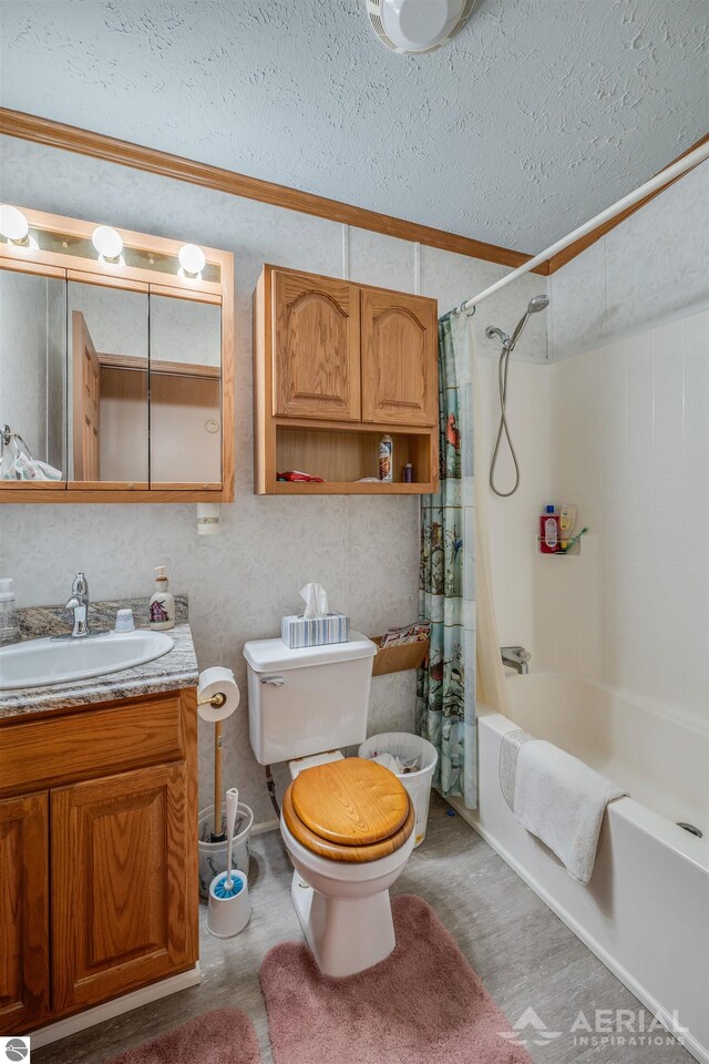 full bathroom with a textured ceiling, toilet, shower / bath combo with shower curtain, vanity, and ornamental molding